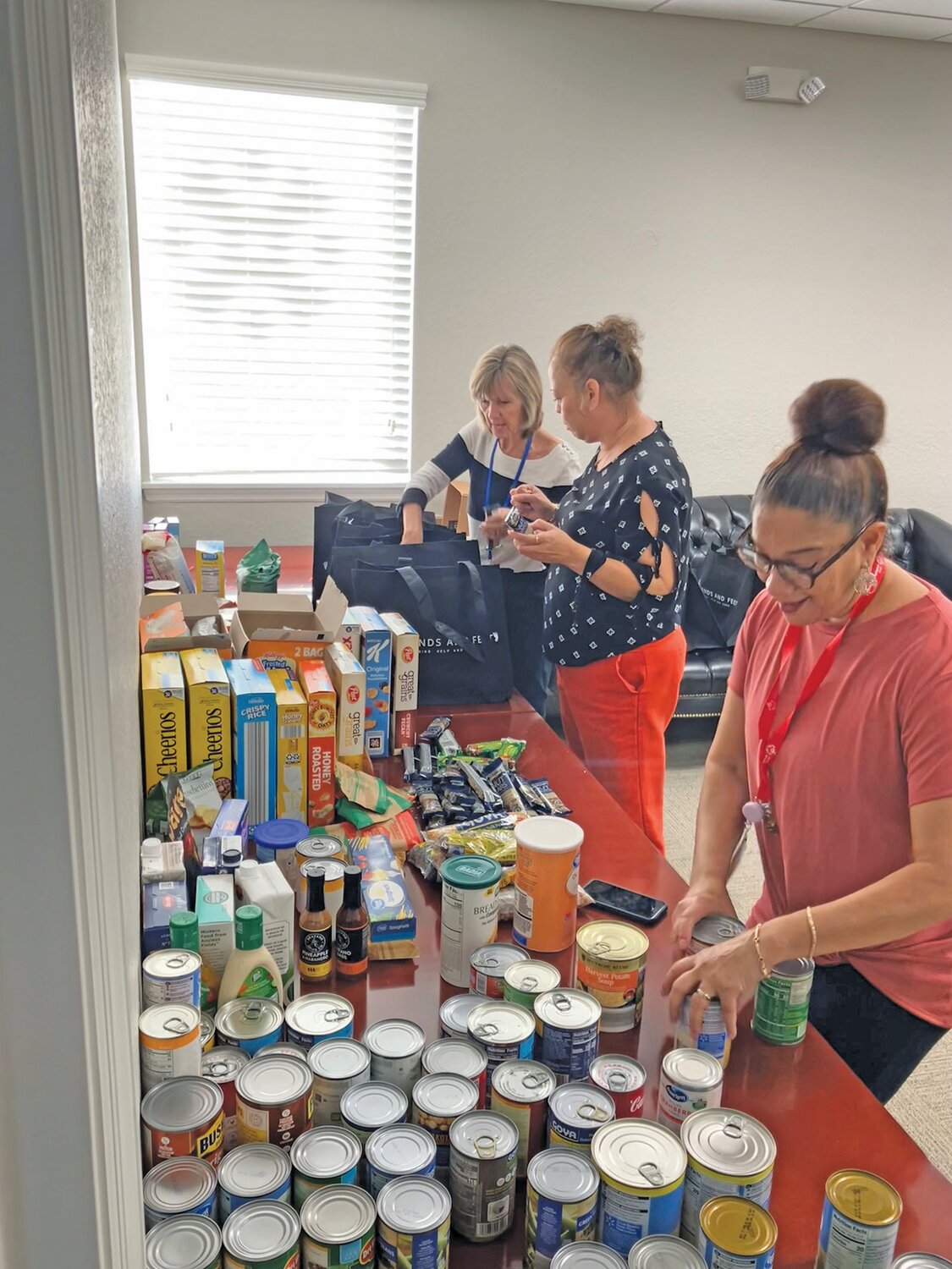 Left to right: Rose Bailey, Martha Winger and Elizabeth Rodriquez sorts food donated to CCKids.